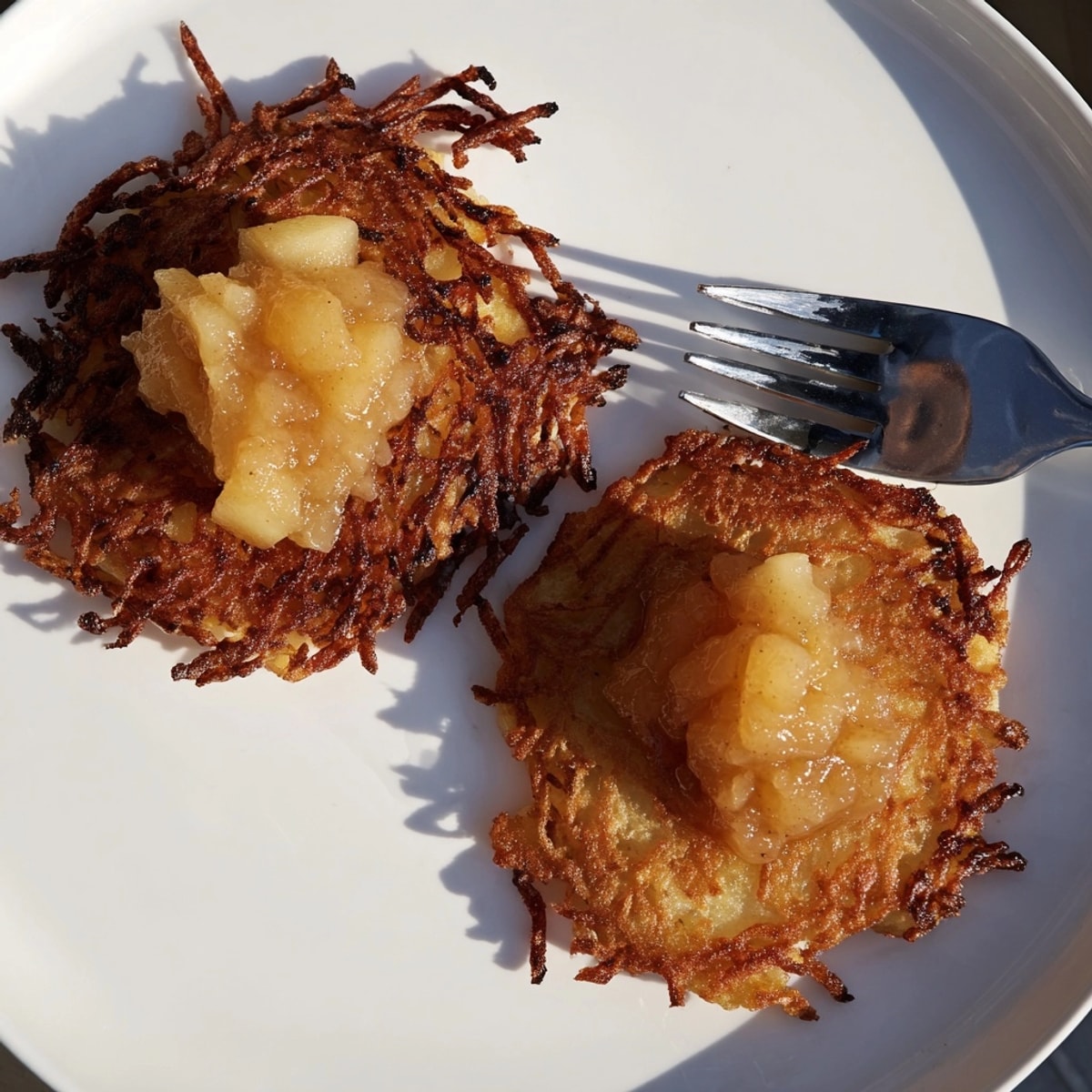 Hausgemachte Kartoffelpuffer mit Apfelmus, ideal als Beilage oder sättigendes Hauptgericht.