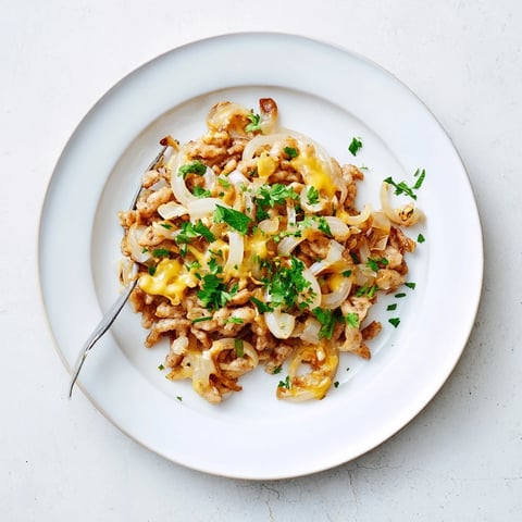 A close-up of a bubbling cheesy spaetzle skillet, golden brown and ready to eat.