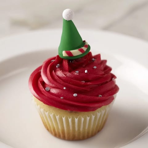 Freshly baked Elf Hat Cupcakes, beautifully decorated with colorful fondant and sprinkles; a sweet treat.