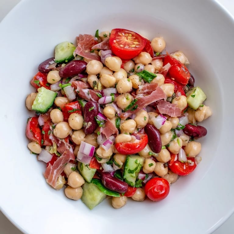 A generous serving of Italian-inspired dense bean salad with prosciutto awaits, ready to be enjoyed.