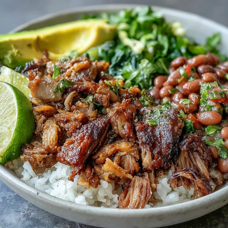 Ein bunter Carnitas Bowl mit knusprigen Schweineshreds, pinto Bohnen, Cilantro und knackigem Limettensaft.
