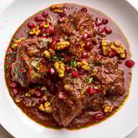 Hearty Iranian Fesenjan stew, simmering with chicken, walnuts, and pomegranate molasses, ready to serve.