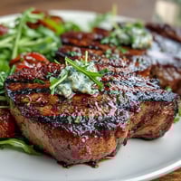 Sommerlicher Salat mit gegrillten Pfirsichen und cremiger Burrata auf frischem Rucola mit Balsamico-Glasur.